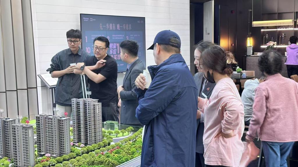 1752134097737053799.jpg 2025年5月1日,在山东青岛某售楼处,购房者正在咨询。新华社记者 张钟仁 摄.jpg